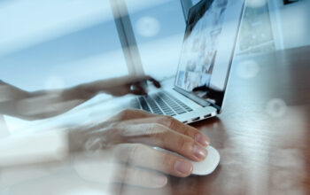 double exposure of business man hand working on laptop computer on wooden desk as concept