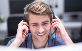 young smiling male call centre operator doing his job with a headset