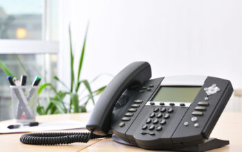 Advanced managerial VoIP phone on beech desk.